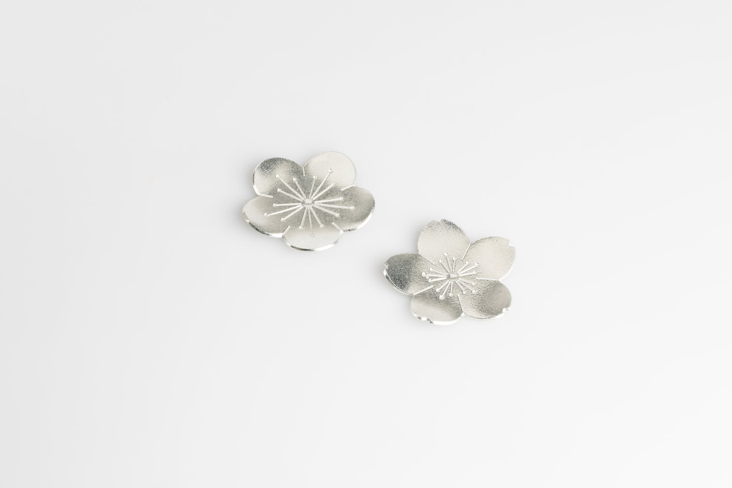 Silver flower-shaped Chopstick Rest on a light gray background