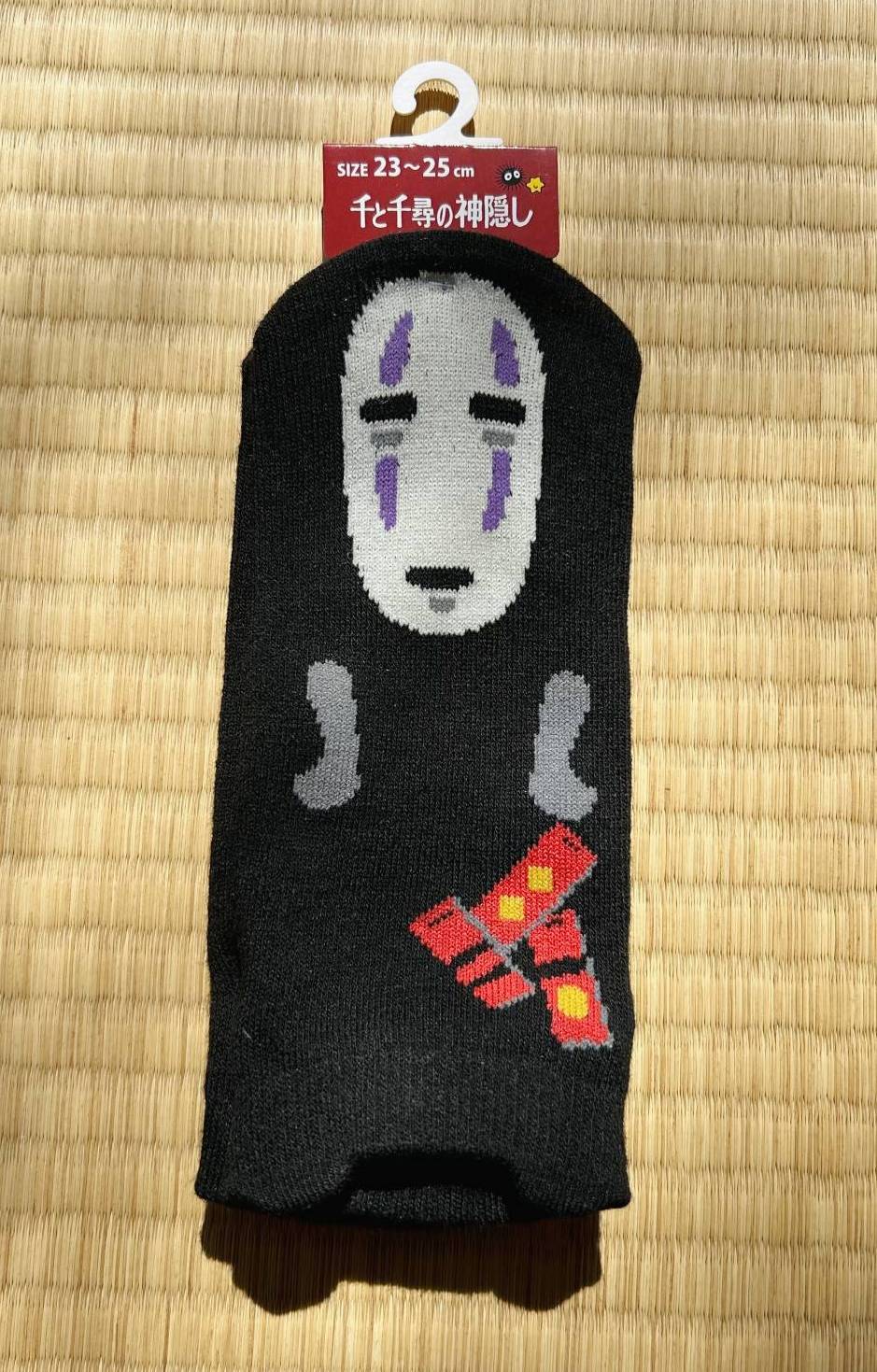 Black sock with a character design on a woven mat background