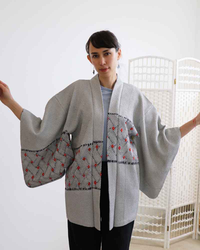 A woman wearing a  blue and gray kimono, facing forward.