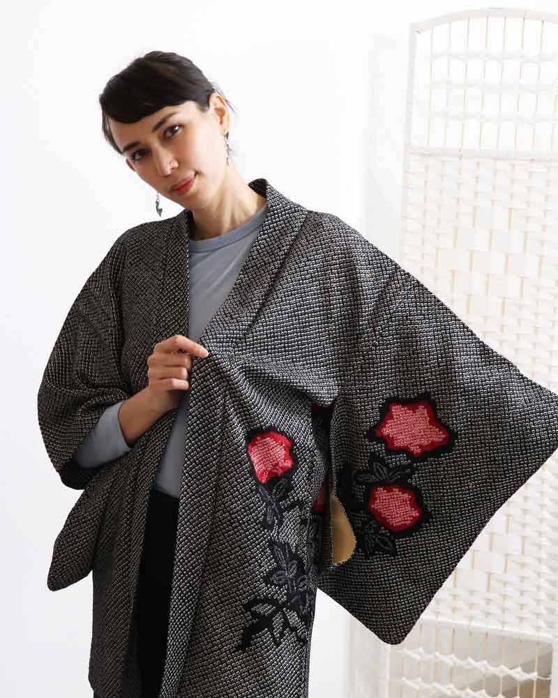 A woman wearing a black kimono, facing forward.