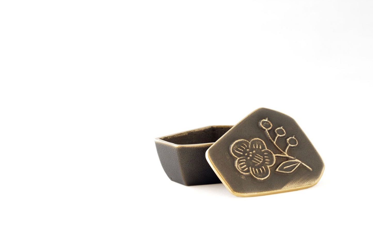 Bronze-colored jewelry box with floral design on a white background