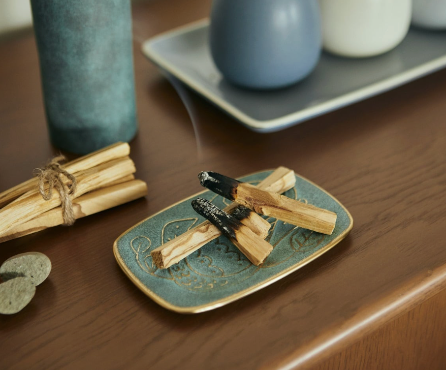 Ceramic dish with wooden sticks on a wooden surface