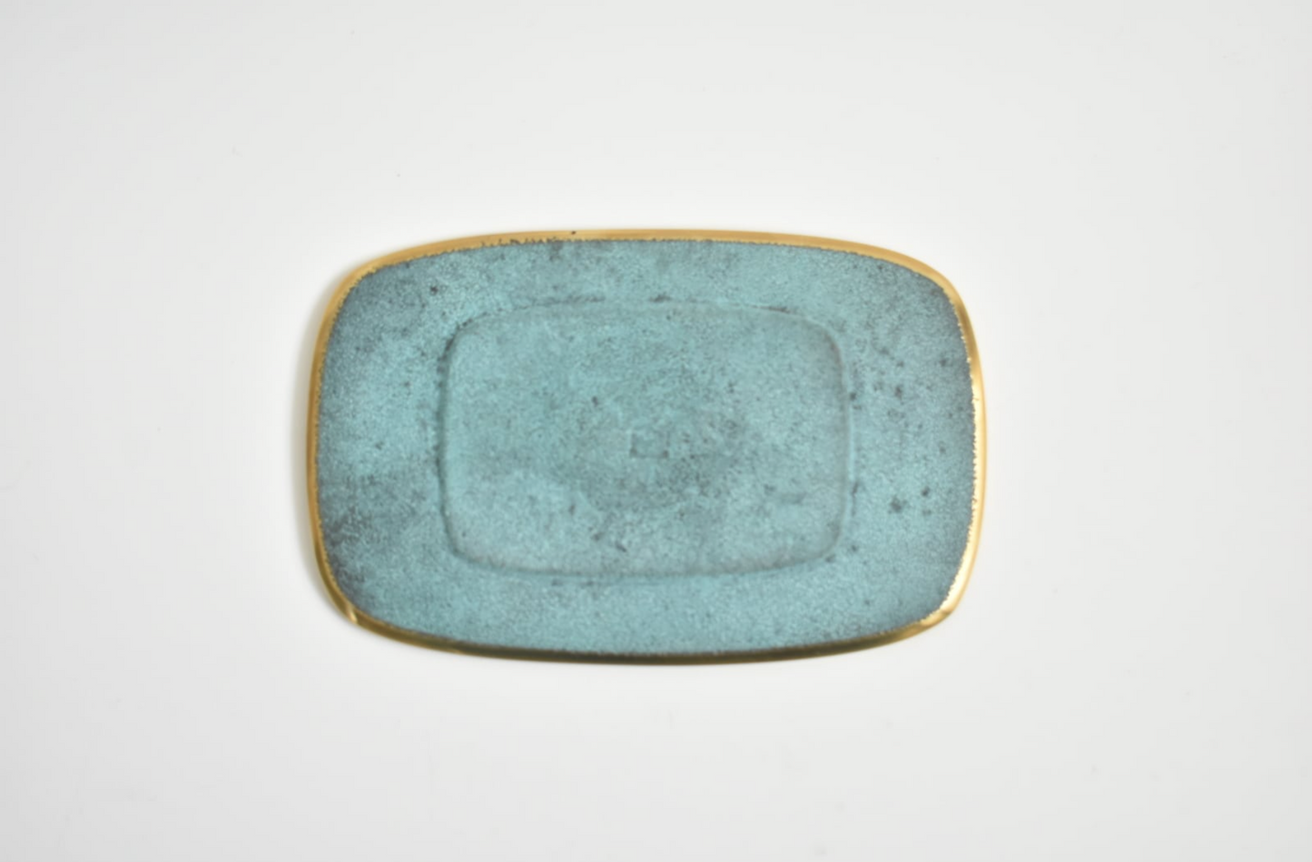 Rectangular ceramic plate with a textured blue surface on a white background
