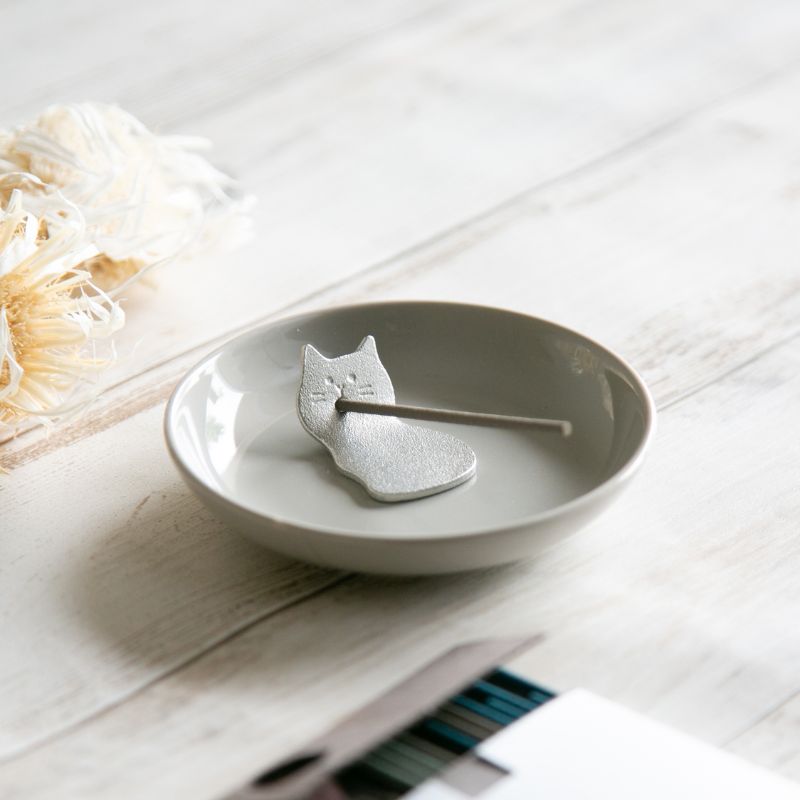 Gray ceramic cat-shaped dish on a light wooden surface