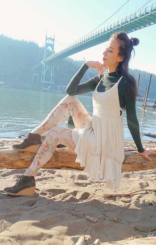 Woman is sitting by the river, wearing antique flower tights.