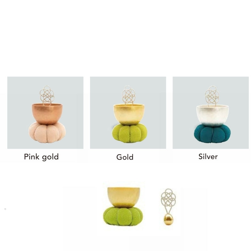 Three decorative items in pink gold, gold, and silver on a gray background