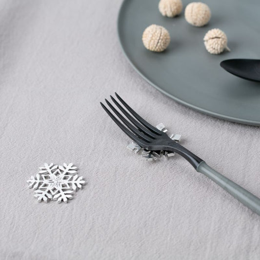 Black decorative fork with snowflake design on a gray surface