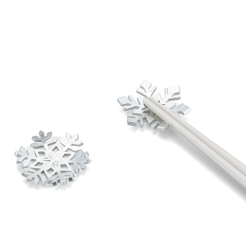 Silver snowflake-shaped stirrer on a white background