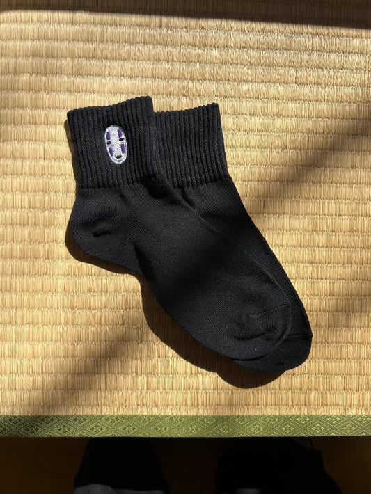 Black sock with a no face charactor on a socks