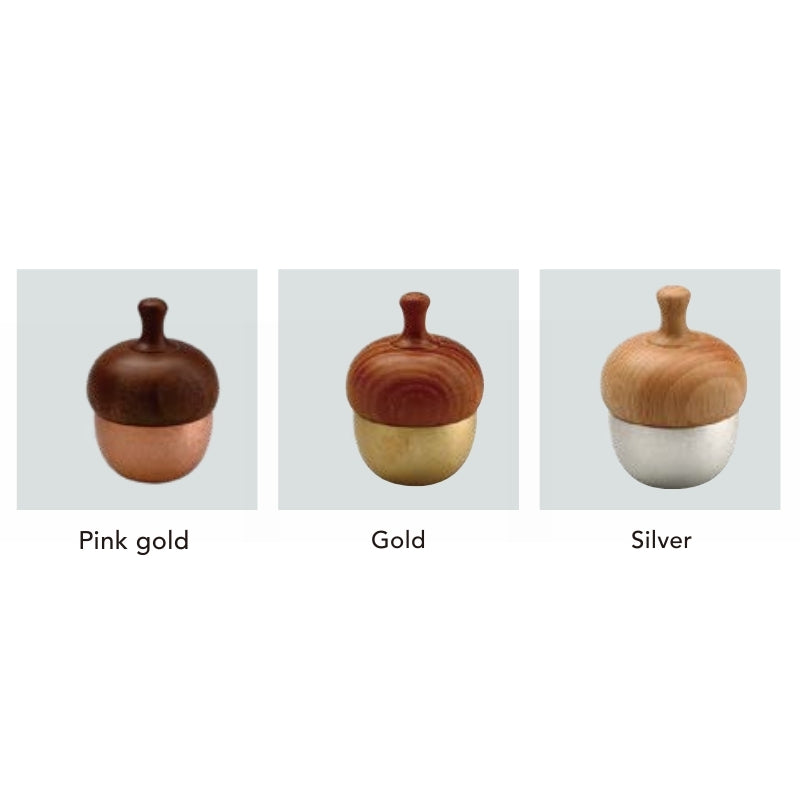 Three acorn-shaped containers in different colors on a light gray background