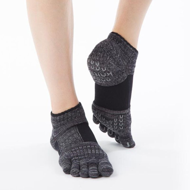 Woman's knee in black wearing Knitido plus brand Arch Support Heather Footie Grip Toe Socks With Power Pads product