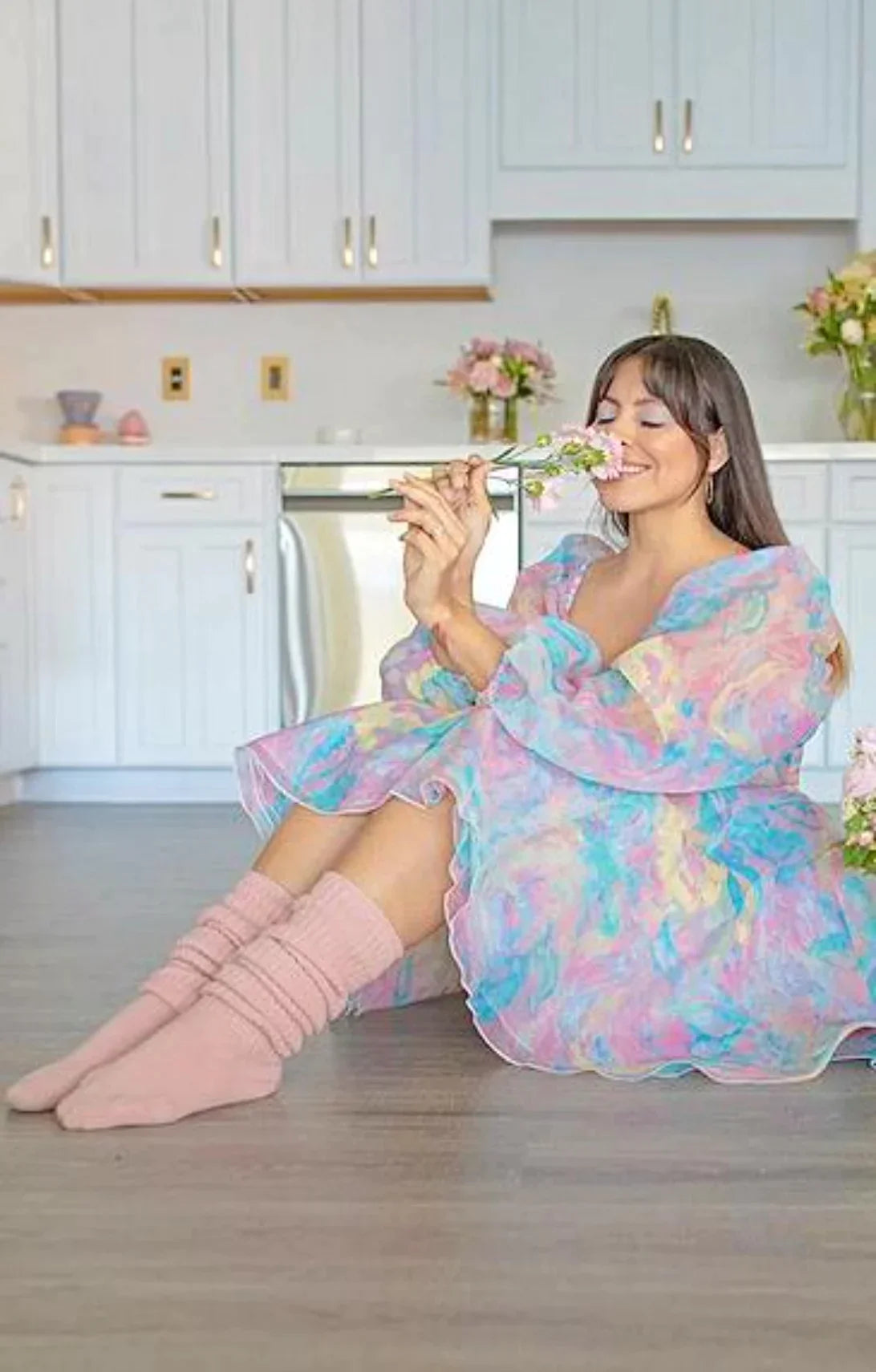 This is a picture of a woman sitting and relaxing with a flower wearing Tabbisocks product name Scrunchy Over The Knee Lounge Wool Blend Socks