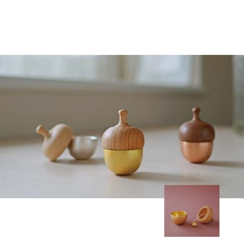 Wooden acorn-shaped containers on a light surface with a blurred background