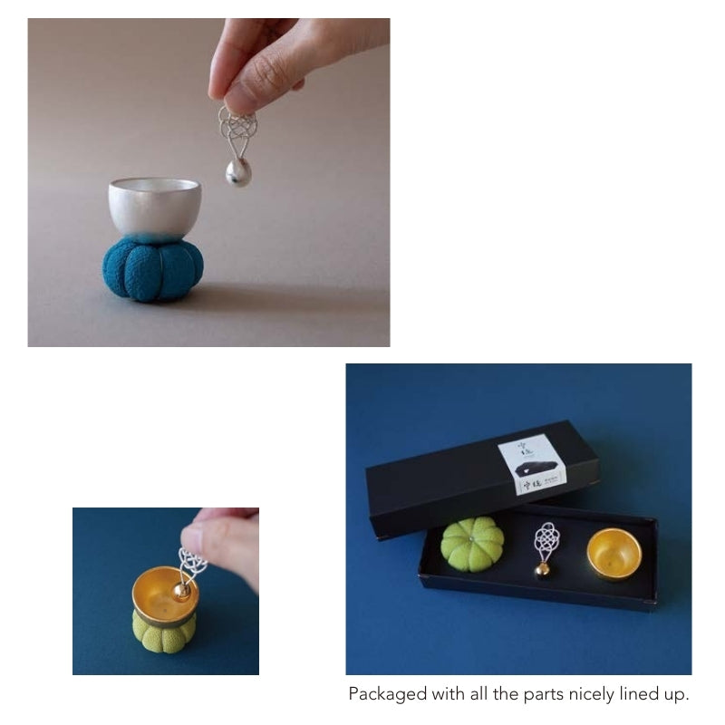 Small ceramic cups and decorative items on a plain background