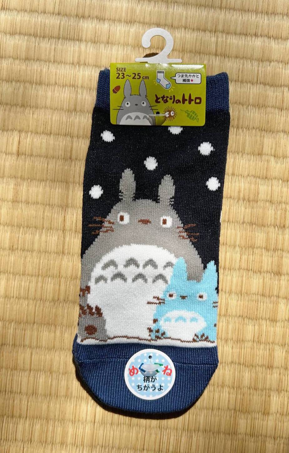 Cartoon character-themed socks on a hanger against a straw mat background
